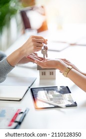 Buying real estate and agreement concept. Real estate agents agree to buy a home and give keys to clients at their agency's offices. 