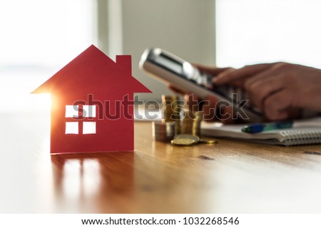 Buying and selling houses and real estate prices concept. Man using calculator to count rent, money or home insurance cost. Calculating mortgage, loan or investment.