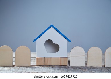 Buying Starter Home. Real Estate Market. Buying And Selling Property Concept. Miniature Of House With Heart Symbol And Wooden Fence