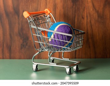 Buying Tennis Equipment Concept.  A Tennis Ball Inside A Shopping Trolley.