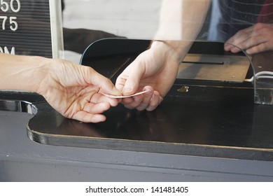 Buying a ticket at a  ticket booth.