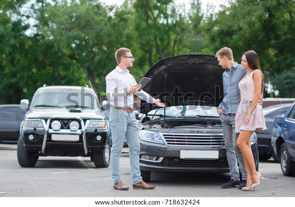 Buying used car. Car\
Dealer Inventory. Used cars store. Male wants to buy the car. Happy\
life. Summer time. Young family. Communication with the seller from\
auto for sale.