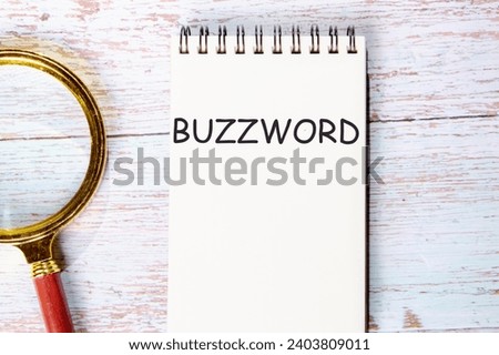 Buzzword a word written on a notebook on wooden boards next to a magnifying glass