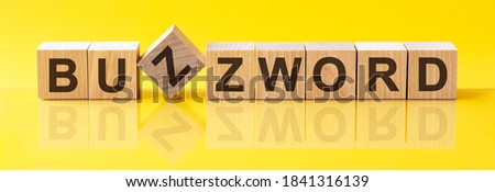 BUZZWORD word written on wood block. sales word is made of wooden building blocks lying on the yellow table. BUZZWORD, business concept, yellow background