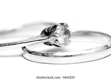 B&W diamond solitaire ring, resting on a wedding ring.