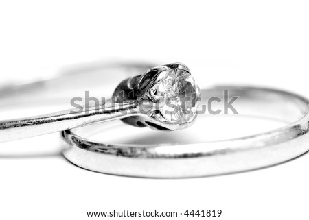 B&W diamond solitaire ring, resting on a wedding ring.