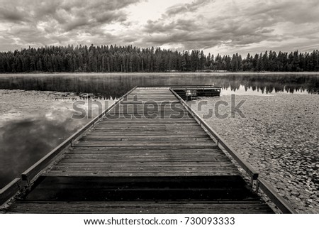 A B&W image of a dock leading out onto Shepard Lake near Sagle, Idaho.