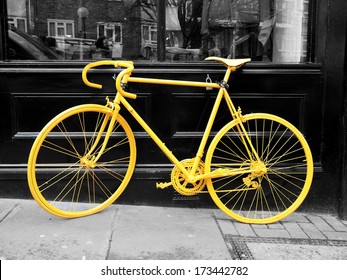 b&w photo of old yellow bike on the window of the coffee shop       