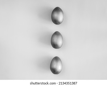 Bw shot of three egg on the grey background. Design, visual art, minimalism, monochrome, black and white photo. Flat lay top view, copy space. Happy Easter concept