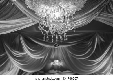 B&W Wedding Ceremony Arches Decorated With Fabrics, Chandeliers And Bouquet.