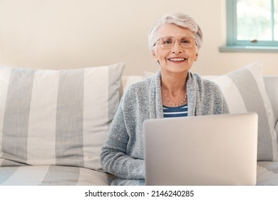 By Far The Easiest Way To Stay Current. Shot Of A Senior Woman Using A Laptop On The Sofa At Home.