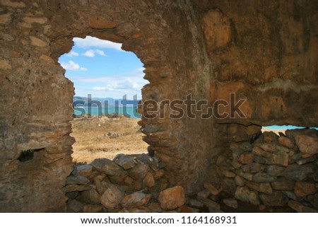 by look through open window at ruins of the ancient coastal city Anamurium, citadel house, walls broken but still partly standing
