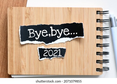 Bye, bye 2021 words on small pieces of paper. Concept for business.