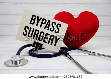 Bypass Surgery text message on paper card with stethoscope on wooden background