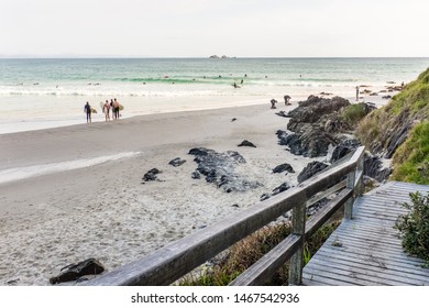 BYRON BAY, AUSTRALIA - SEPTEMBER 20, 2014: Surfers standing on the shore or in the water at Wategos Beach, Byron Bay, NSW, Australia