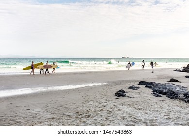 BYRON BAY, AUSTRALIA - SEPTEMBER 20, 2014: Surfers walking towards the water at Wategos Beach, Byron Bay, NSW, Australia