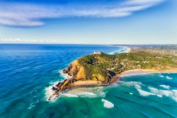 Byron Bay Lighthouse High On The Rocky Headland - The Most Eastern Point Of Australian Continent Facing Pacific Ocean In Elevated Aerial Seascape Above Coast.