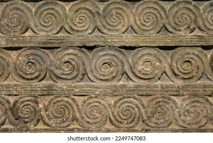 Byzantine ornament, pattern carved in old stone wall, ancient texture background, vintage geometric relief. Decoration of Roman Greek architecture. Theme of antique, wallpaper, swirl, spiral.