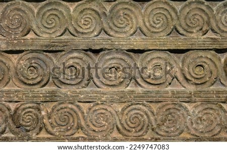 Byzantine ornament, pattern carved in old stone wall, ancient texture background, vintage geometric relief. Decoration of Roman Greek architecture. Theme of antique, wallpaper, swirl, spiral.