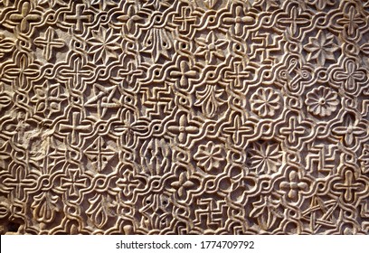 Byzantine Patterned Ornament Carved In Stone Wall, Ancient Texture Background, Detail Of Interior With Geometric Relief. Symbols Pattern Inscribed On Marble, Decoration Of Roman Greek Architecture.