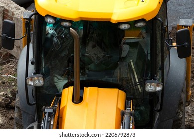 Cab Of A Bulldozer At A Construction Site. The Work Of A Universal Machine Designed For Digging Soil, Planning Sites For Construction, Cleaning The Territory, Digging Trenches.