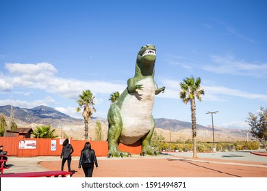 Cabazon, California/United States - 11/22/2019: Tourists Approach The Tyrannosaurus Rex Figure At The Cabazon Dinosaur Roadside Attraction