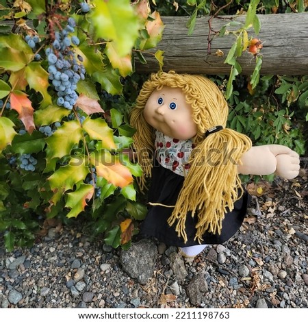 cabbage patch kid,outside examining the grapes