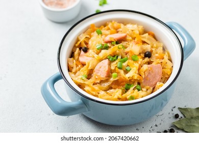 Cabbage sausage stew in a pot. Top view, copy space.