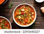 Cabbage soup in bowl over wooden background. Top view, flat lay
