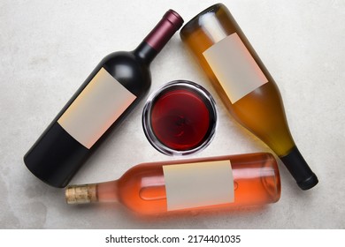 Cabernet, Rose, Chardonnay: Overhead View Of A Group Of Three Different Bottles With Blank Labels Arranged In A Triangle With A Glass Of Wine In The Middle.