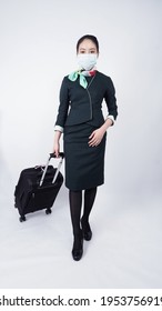 Cabin Crew Or Air Hostess With Face Mask In Covid 19 Pandemic. Flight Attendant Wear Medical Mask To Prevent Coronavirus Infection. New Normal Lifestyle In Airline Business. Pretty Stewardess Woman.