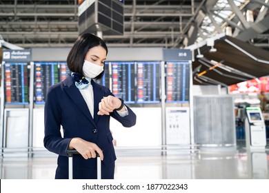 Cabin Crew Or Air Hostess Wearing Face Mask Walking In Airport Terminal To The Airplanel During The COVID Pandemic To Prevent Coronavirus Infection. New Normal Lifestyle In Air Transport Concept.