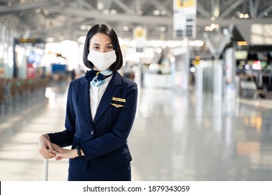 Cabin Crew Or Air Hostess Wearing Face Mask Walking In Airport Terminal To The Airplanel During The COVID Pandemic To Prevent Coronavirus Infection. New Normal Lifestyle In Air Transport Concept.