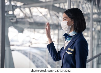 Cabin Crew Or Air Hostess Wearing Face Mask Walking In Airport Terminal To The Airplanel During The COVID Pandemic To Prevent Coronavirus Infection. New Normal Lifestyle In Air Transport Concept.