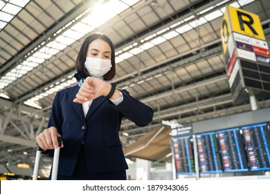 Cabin Crew Or Air Hostess Wearing Face Mask Walking In Airport Terminal To The Airplanel During The COVID Pandemic To Prevent Coronavirus Infection. New Normal Lifestyle In Air Transport Concept.