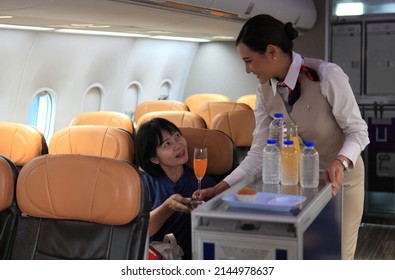 Cabin Crew Pushing Service Cart And Serve To Customer On The Airplane During Flight. Hostess Service On Plane 