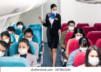 Cabin Crew Walking Around To Check Safety On The Airplane Before Plane Taking Off. New Normal, Flight Attendant And All Passengers Wearing Face Mask To Prevent COVID Infection During Virus Pandemic.