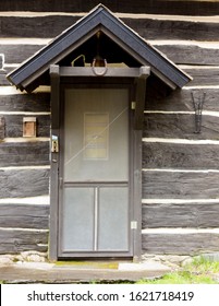 Cabin Door In Northern Michigan With A Horse Shoe Above The Door.  Wood Cabin With White Mud Packed Into The Cracks