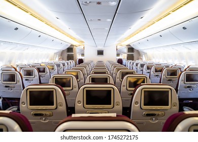 Cabin Inside Of Commercial Passenger Wide Body Aircraft. 9 Seats Per Row With Twin Aisle Airplane Is A Jet Airliner With A Fuselage Wide Enough To Accommodate Two Passenger Aisles. Modern Aviation.