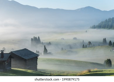 A Cabin On A Hill With Mist In The Air Surrounded By Mountains And Trees In Zermatt, Switzerland