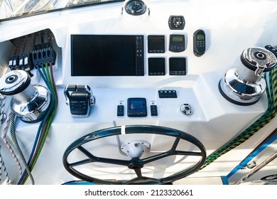 Cabin of a sailing yacht. Navigation pad with steering wheel, sailing winches with cables, shift lever, boat computer and compass.