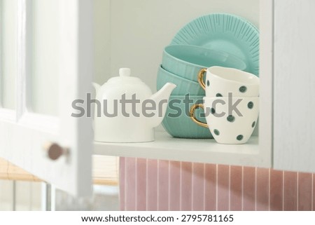 Cabinet with different clean dishware in kitchen, closeup