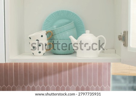 Cabinet with different clean dishware in kitchen, closeup