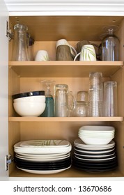 A Cabinet Full Of Plates, Glasses, And Dishes.