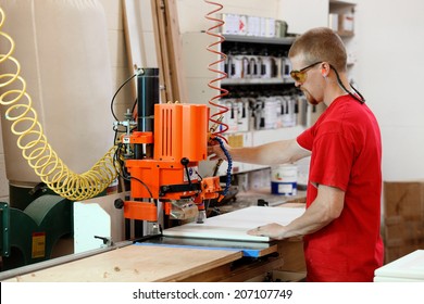 A cabinet maker operated a hinge mortising machine in a cabinet shop