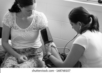 CABLE BAY, NZ - Dec 12 2013:Midwife Checks Pregnant Woman Blood Pressure. In Pregnancy, It's The Fetal Heart That Builds Up The Blood Pressure To Drive Its Blood Through The Circulation. 