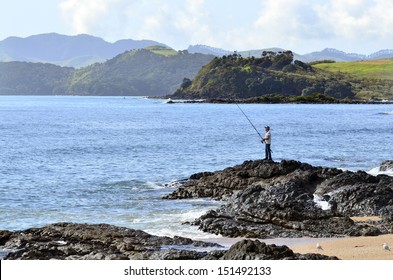 CABLE BAY,NZ- AUG 22:Mature Man Fishing From A Rock On Aug 22 2013.New Zealand Exclusive Economic Zone Covers 4.1 Million Square Kilometers And It's The Sixth Largest Zone In The World.