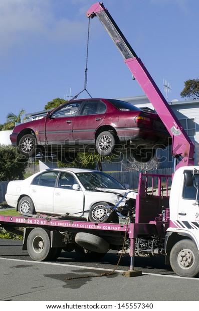 CABLE BAY,NZ - JULY 01:Man towing damaged car on\
tow truck on July 01 2013.In Australia exists a Tow Truck Act, and\
tow trucks are identified by number plates ending in \