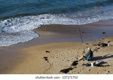 CABLE BAY,NZ-APR 22:Man Fishing From The Beach On April 22 2013.New Zealand Exclusive Economic Zone Covers 4.1 Million Square Kilometers And It's The Sixth Largest Zone In The World.