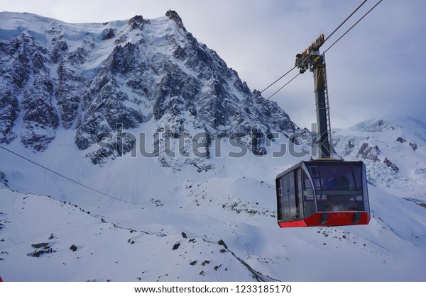 A\
cable car going down from the top of snow mountains\
